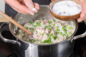 Risi Bisi Reis mit Salz würzen
