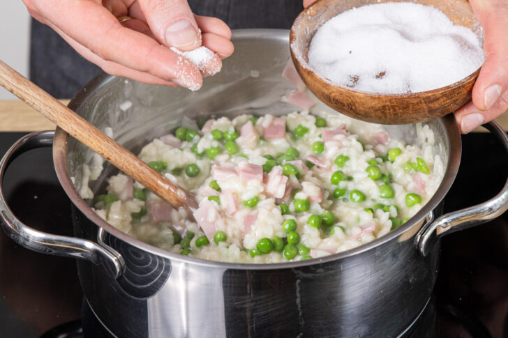 Risi Bisi Reis mit Salz würzen