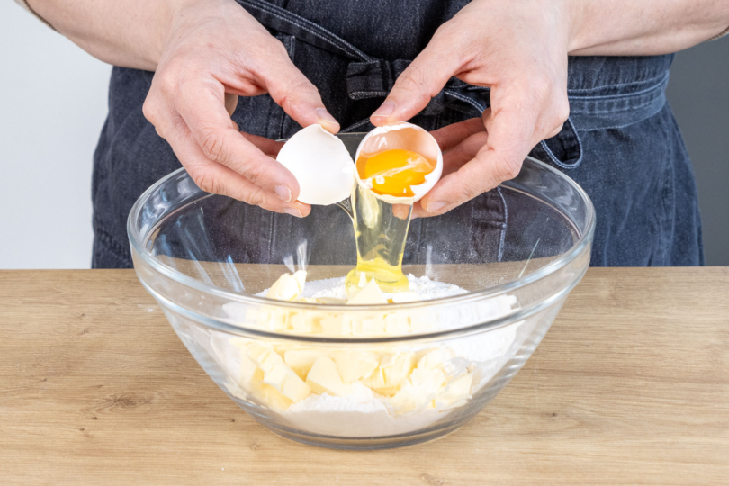 Ei und Butter zum Mehl in die Schüssel geben