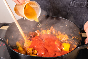 passierte Tomaten, Ketchup und Apfelsaft in den Bräter geben