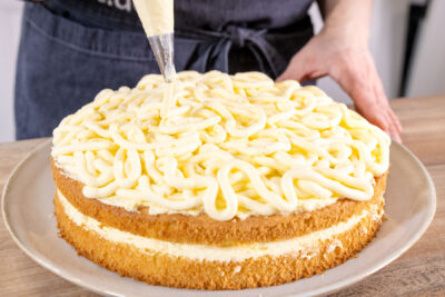 Sahnecreme auf die Spaghettieis-Torte spritzen