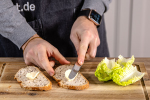 Brotscheiben mit Butter bestreichen
