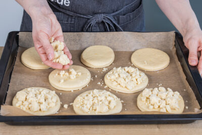 Butterstreusel auf den Hefetalern verteilen