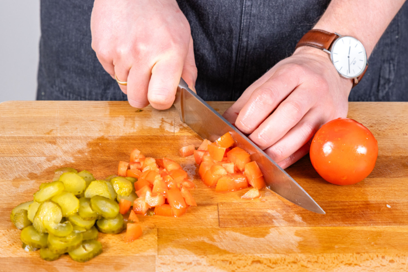 Gewürzgurken und Tomaten schneiden