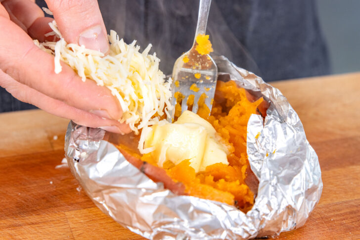 heiße Süßkartoffel mit Butter und Gouda füllen