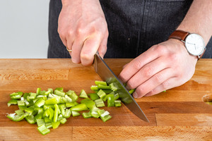 Grüne Spitzpaprika in Würfel schneiden
