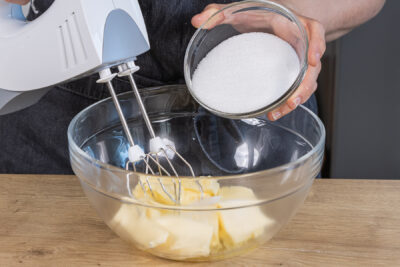 Zucker in eine Schüssel mit Butter geben