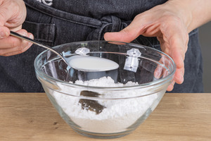 Milch in eine Schüssel mit Puderzucker und Vanillepaste geben