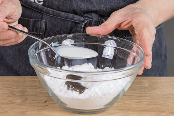 Milch in eine Schüssel mit Puderzucker und Vanillepaste geben