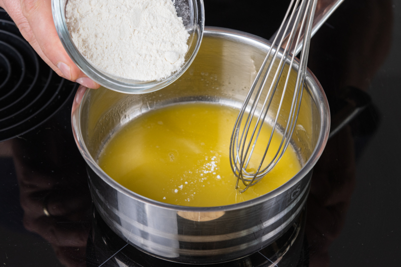 Mehl in den Topf zur geschmolzenen Margarine geben