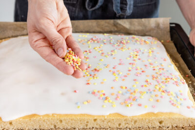 Veganen Fantakuchen mit Zuckerstreusel dekorieren