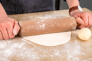 Hefeteig zu dünnen Pizzen ausrollen