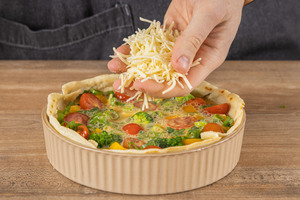 Wrap-Quiche mit Reibekäse bestreuen