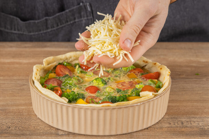 Wrap-Quiche mit Reibekäse bestreuen