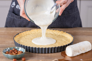 Füllung für die Ziegenkäse-Birnen-Tarte hineingeben