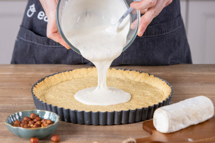 Füllung für die Ziegenkäse-Birnen-Tarte hineingeben