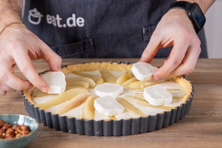 Ziegenkäse auf der Tarte verteilen