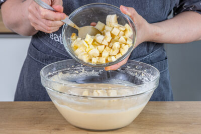 Apfel- und Bananenwürfel in die Schüssel geben