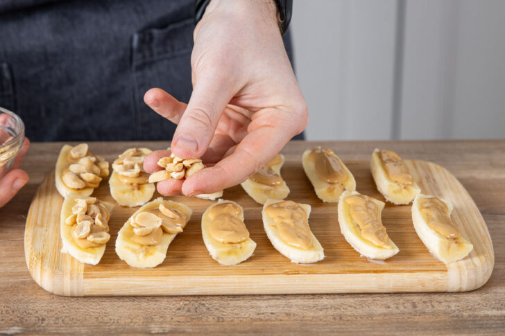 Erdnüsse auf die Bananen streuen