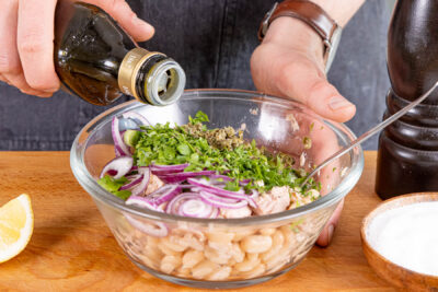 Bohnensalat mit Thunfisch abschmecken und vermengen