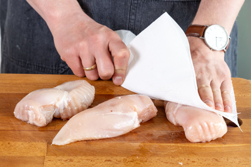 Hähnchenfleisch mit Küchenpapier abtupfen