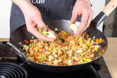 Frühlungszwiebel und Limette zum Bratreis mit Ei geben