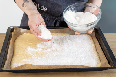 Zucker-Kokos-Mischung über dem Buttermilchkuchen verteilen