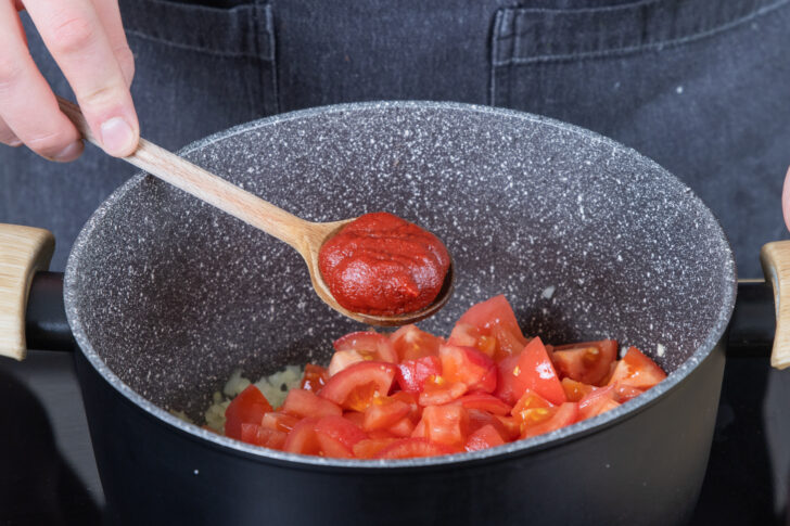 Tomatenmark in den Topf geben