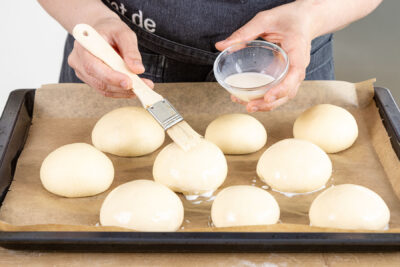Milchbrötchen mit Milch bestreichen