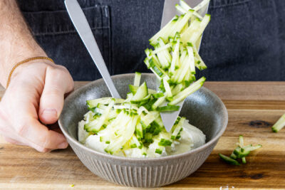 Gurke in feine Streifen schneiden und zum Quark geben