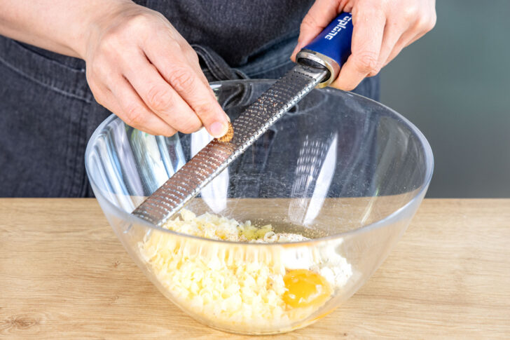 Frischkäse, Bergkäse, Ei und Gewürze vermengen