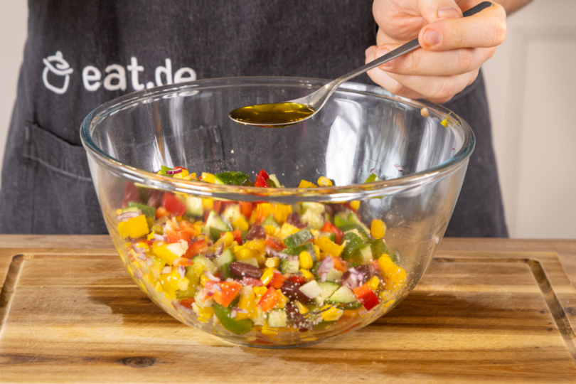 Olivenöl zum Kidneybohnen-Mais-Salat geben