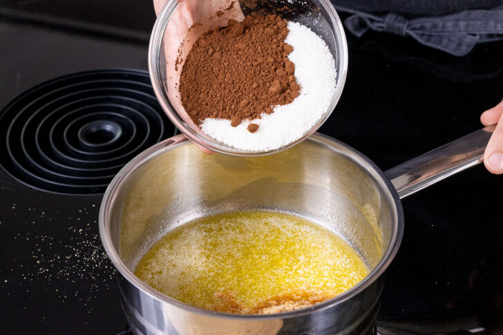 Kokosrapel, Zucker und Kakao zur geschmolzenen Butter geben