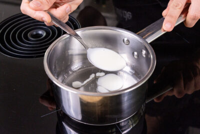 einen Löffel Creme zu der Gelatine geben