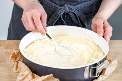 Teig für Kokos-Quarkkuchen in Springform verstreichen