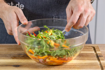 Mangosalat mit Rucola mischen