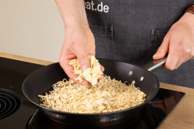 Mandelblättchen mit Mie-Nudeln anrösten.
