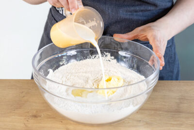 Eiweiß, Butter und Milch zum Teig geben