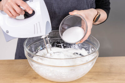 Zucker zum Eiweiß geben