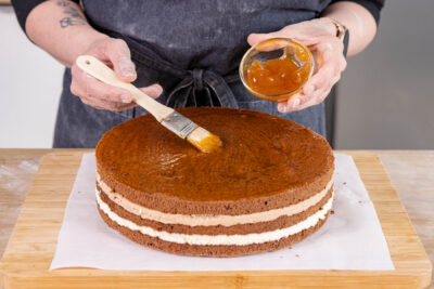 Mozarttorte mit Aprikosenmarmelade bestreichen