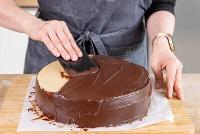 Mozarttorte mit Ganache bestreichen