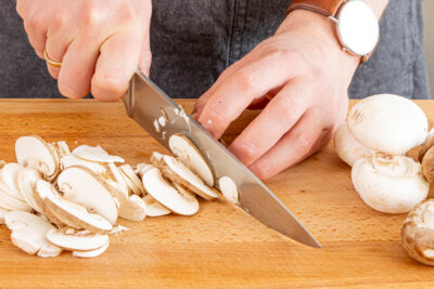 Champignons putzen und in Scheiben schneiden