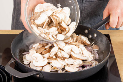 Zwiebeln, Knoblauch und Champignon anbraten