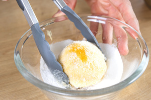 Quarkbällchen in Zucker wälzen