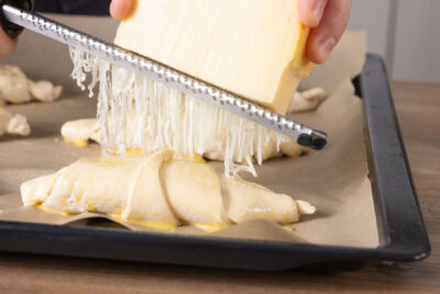 Schinken-Käse-Croissants mit Käse bestreuen
