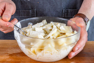 Selleriesalat nach Omas Rezept durchmischen