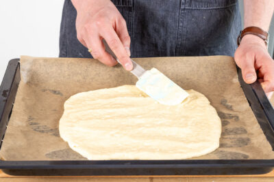 Käse-Ei-Masse auf dem Backblech verstreichen