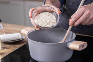 Risotto-Reis mit in den Topf geben