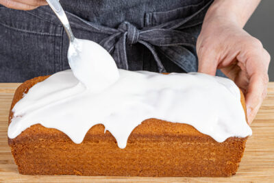 Zuckerguss über Zitronenkuchen geben