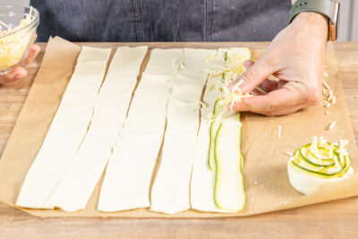 Blätterteigstreifen mit Käse bestreuen